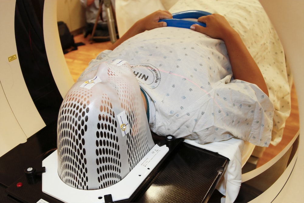 A Woman in a Hospital Gown Undergoing a Tumour CT scan Before Radiation Therapy